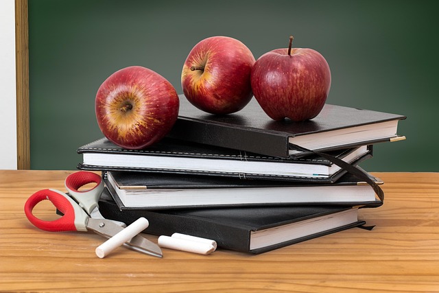 Three apples on top of a stack of books